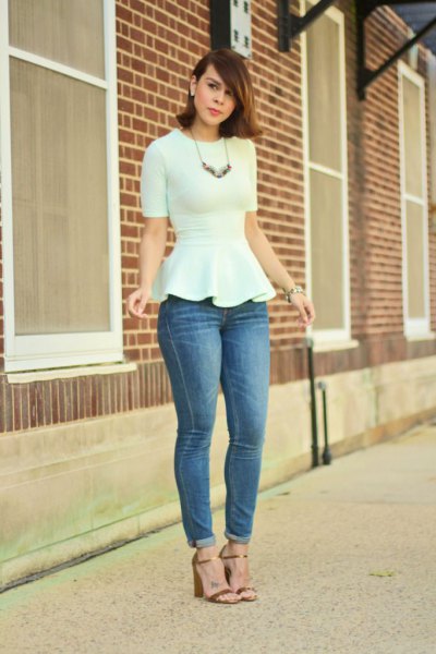Figure-hugging white peplum blouse paired with skinny jeans with blue cuffs