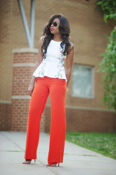 white sleeveless peplum blouse with floral embroidery and red wide-leg pants
