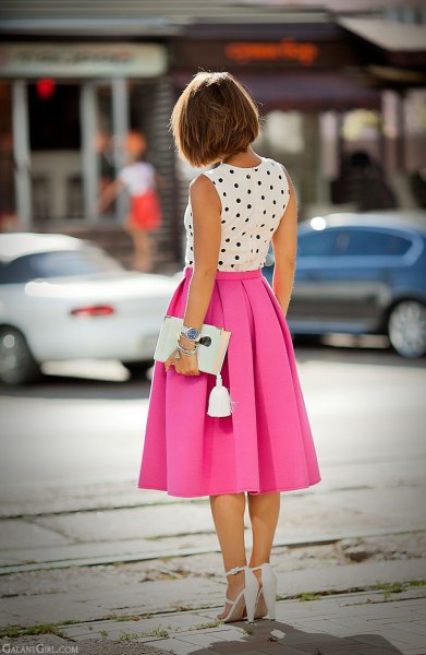 sleeveless blouse with white and black polka dots and a pink pleated midi skirt