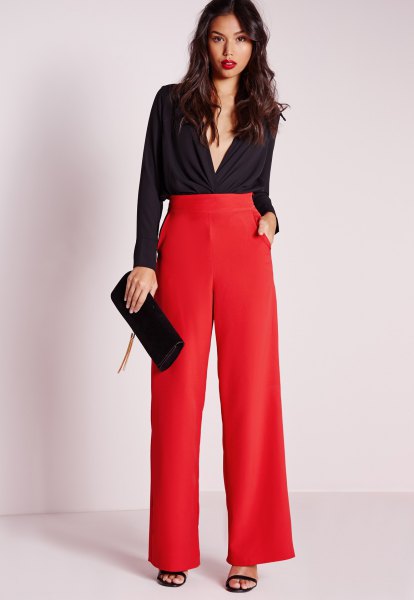 black blouse with a deep V-neck and red pants with a high waist and wide legs