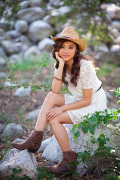 Straw cowboy hat with a white lace mini dress with short sleeves and a belt
