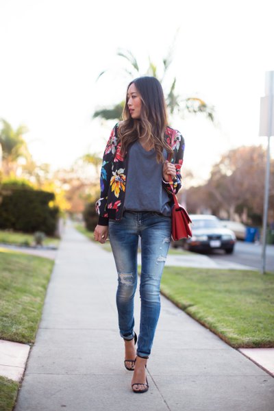 black floral bomber jacket with gray sweater and ripped skinny jeans