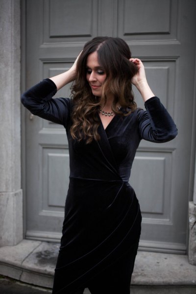 Knee-length black velvet dress with silver statement chain