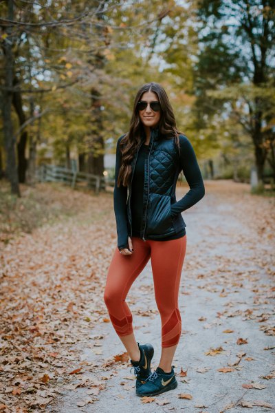 black leather down vest with fitted sweater and green leggings