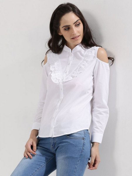 white shirt with ruffles in front and light blue skinny jeans