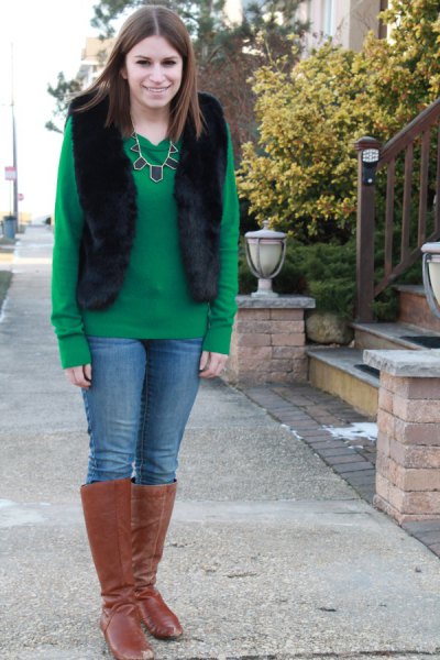 green sweater with black vest and camel suede knee high boots