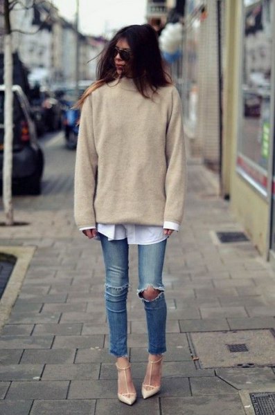 Blush pink knit sweater worn with a white button down shirt and ripped knee jeans