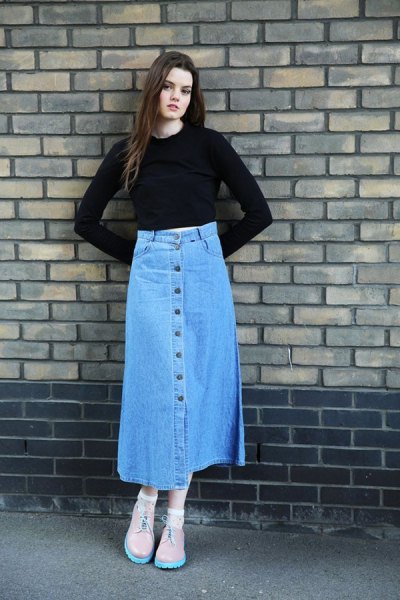 black, slightly cropped top with bell sleeves and blue skirt with a long jeans button in front