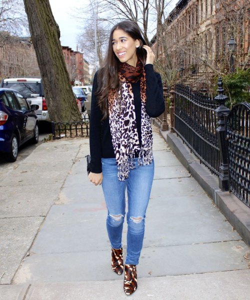black sweater with leopard print scarf and light blue jeans
