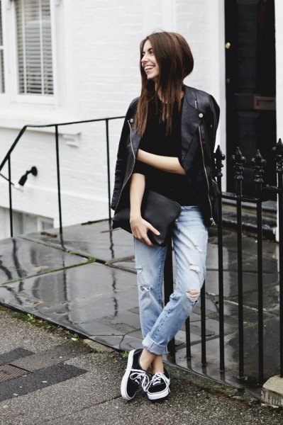 black leather jacket with cuffed jeans and clutch
