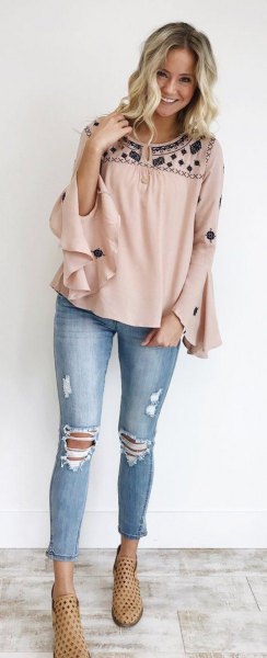 blush and black blouse with wide ruffled sleeves and ripped and cropped jeans