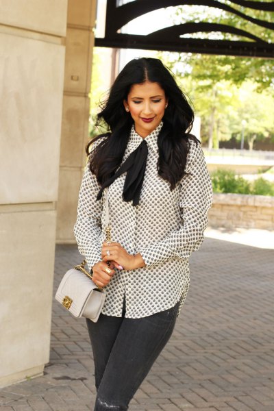 white and black patterned tie blouse gray jeans
