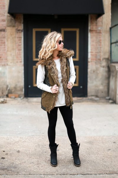 White crew neck sweater and olive faux fur military vest