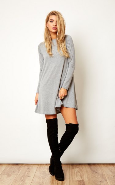 gray long-sleeved swing dress with black over-the-knee boots