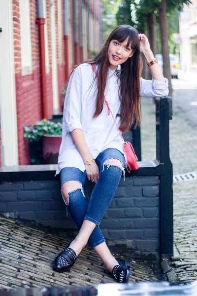 Button-up shirt with badly ripped blue jeans