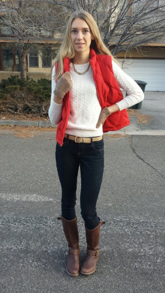 red vest with white knitted sweater with round neckline and black skinny jeans