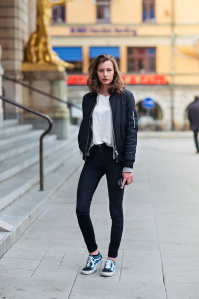black bomber jacket with dark skinny jeans and dark blue shoes