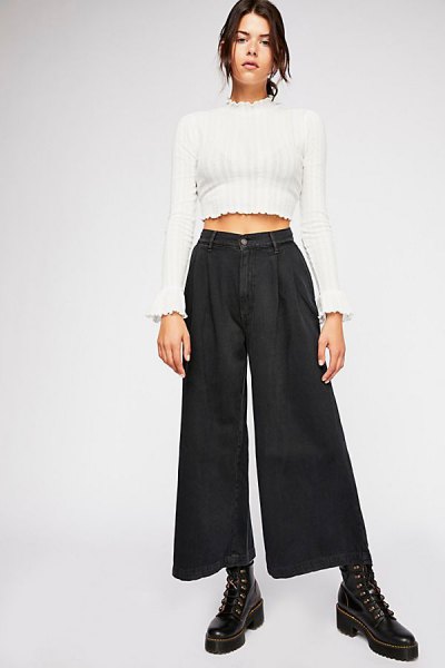 white cropped mock-neck sweater and black pleated jeans