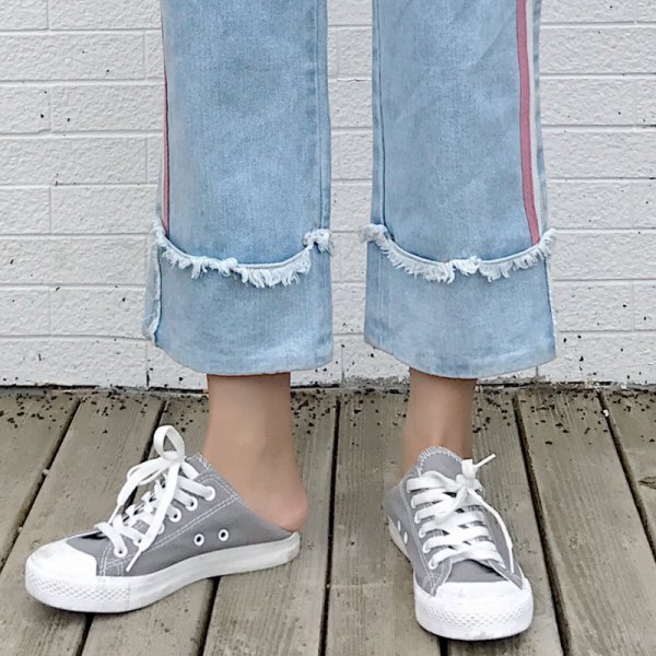 Light blue pleated cropped jeans with cuffs and gray and white canvas sneakers