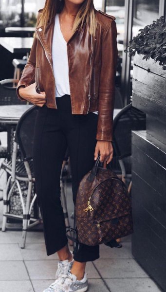 Leather jacket worn with white scoop neck blouse and short black pants