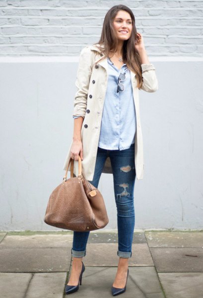 beige long coat with light blue shirt and ripped skinny jeans