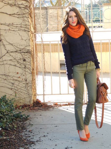black sweater with orange knitted scarf and gray chinos