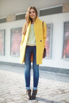yellow long wool coat with white sweater and cuffed jeans