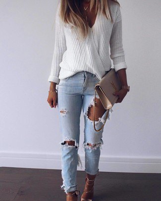 white oversized v-neck sweater and blue ripped slim fit jeans