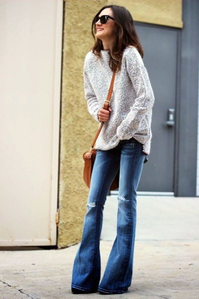 heather gray sweater with blue ripped flared jeans