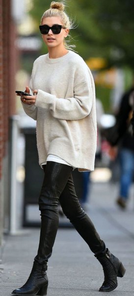 white, thick sweater with a round neckline and black leather pants