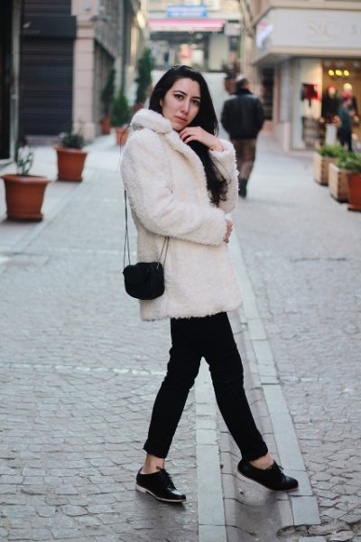 white faux fur collared coat with black jeans and buck shoes
