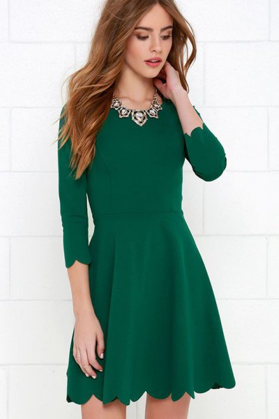 green skater cocktail dress with a scalloped hem and three-quarter sleeves