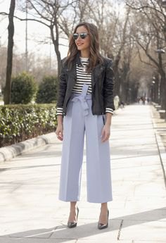 black bomber jacket with black and white striped sweater and blue wide-leg pants