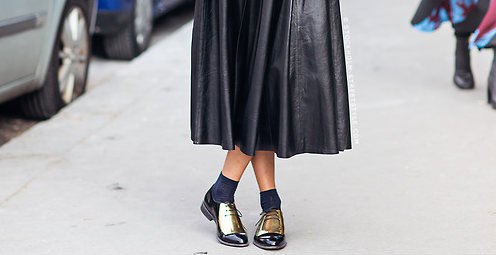 black midi pleated leather dress with crew socks and gold wintip oxfords