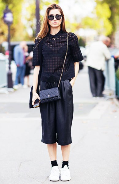 black, semi-transparent short-sleeved blouse with cropped pants with wide legs made of leather