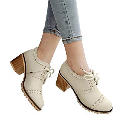 Wingtip shoes with ivory heels and light blue skinny jeans