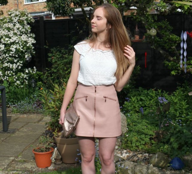 Crochet top with white cap sleeves and pink leather mini skirt with front zip closure