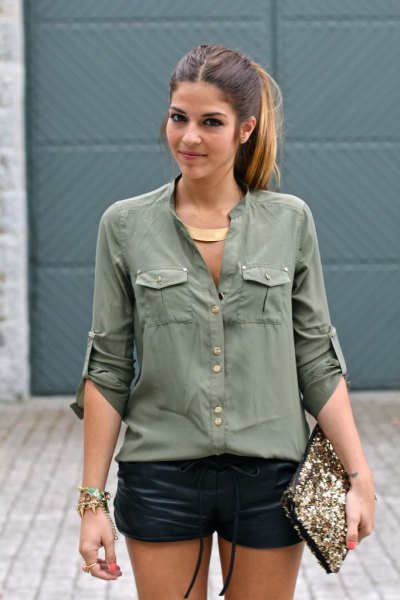 green oversized shirt with front pocket and black mini leather shorts
