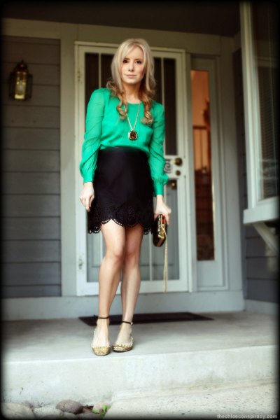 Buttonless blouse paired with a black mini skirt with a high waist and scalloped edge