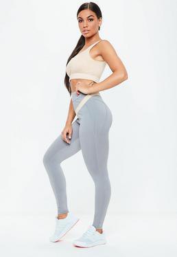 Light pink crop top with gray high waisted seamless leggings and white sneakers