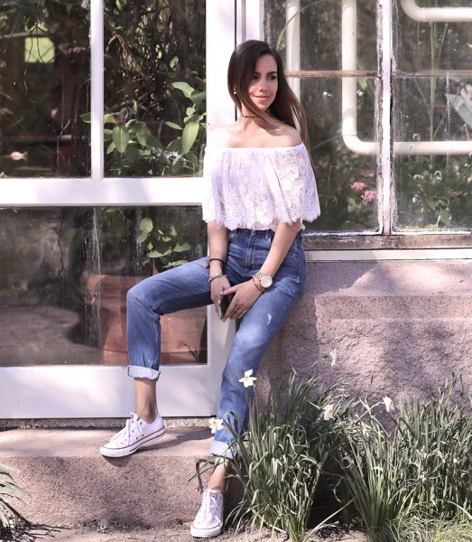 white lace off the shoulder top with jeans and cuffed sneakers