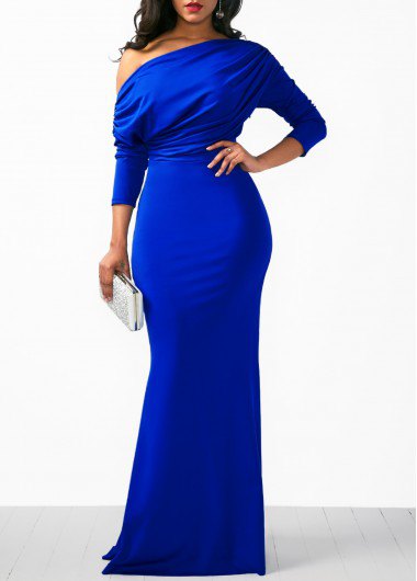 A strapless royal blue long sleeve dress with a white clutch wallet