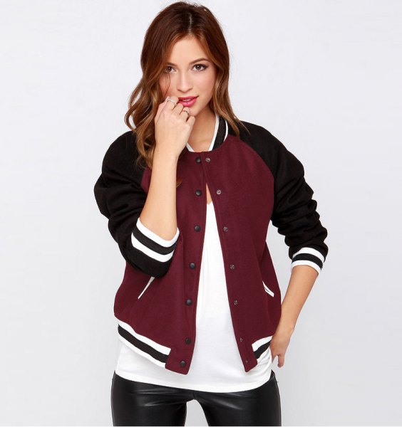 casual black and burgundy baseball jacket with white t-shirt and leather leggings