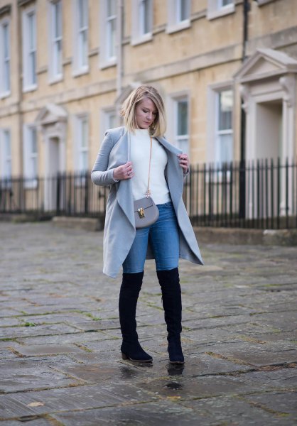 white sweater with gray long coat and blue high-rise jeans