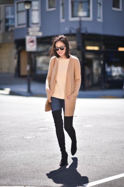 blush pink long jacket with blue tall jeans and black overknee boots