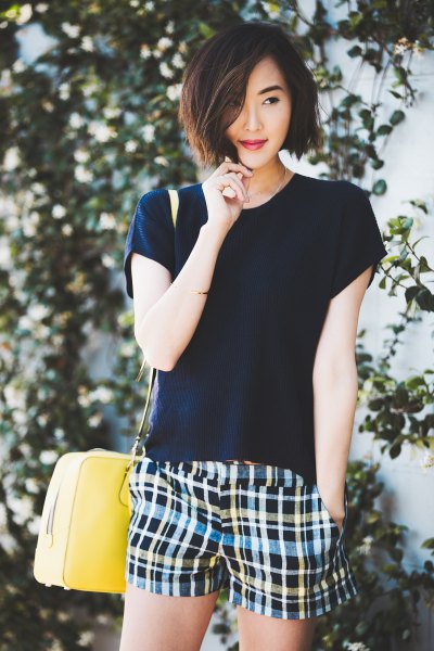 black t-shirt with multicolored plaid shorts
