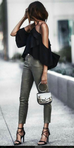 black halterneck blouse with cold shoulder ruffles and gray skinny jeans