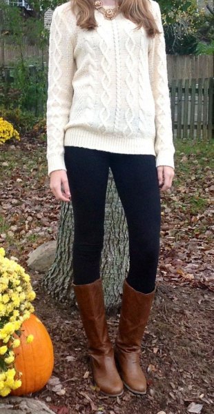 white knit sweater with black leggings and brown leather knee high boots