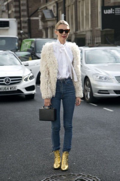 white faux fur jacket with white bow tie and gold boots
