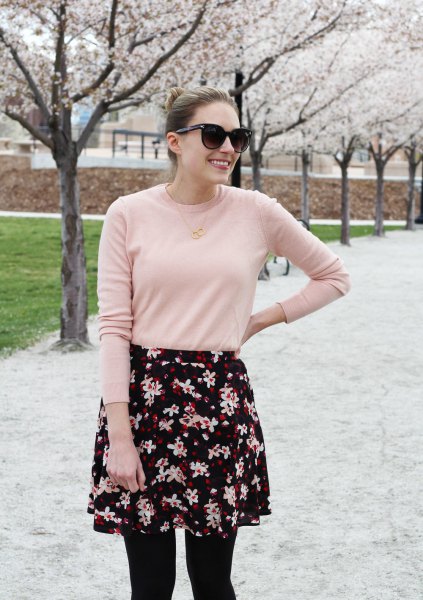Blush pink sweater worn with a black and white floral mini skirt